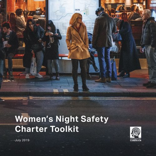 Women's Night Safety Charter Toolkit. A woman stands alone at a bustop at night. Behind her people mill about the bustop and further back still is a busy restaurant.